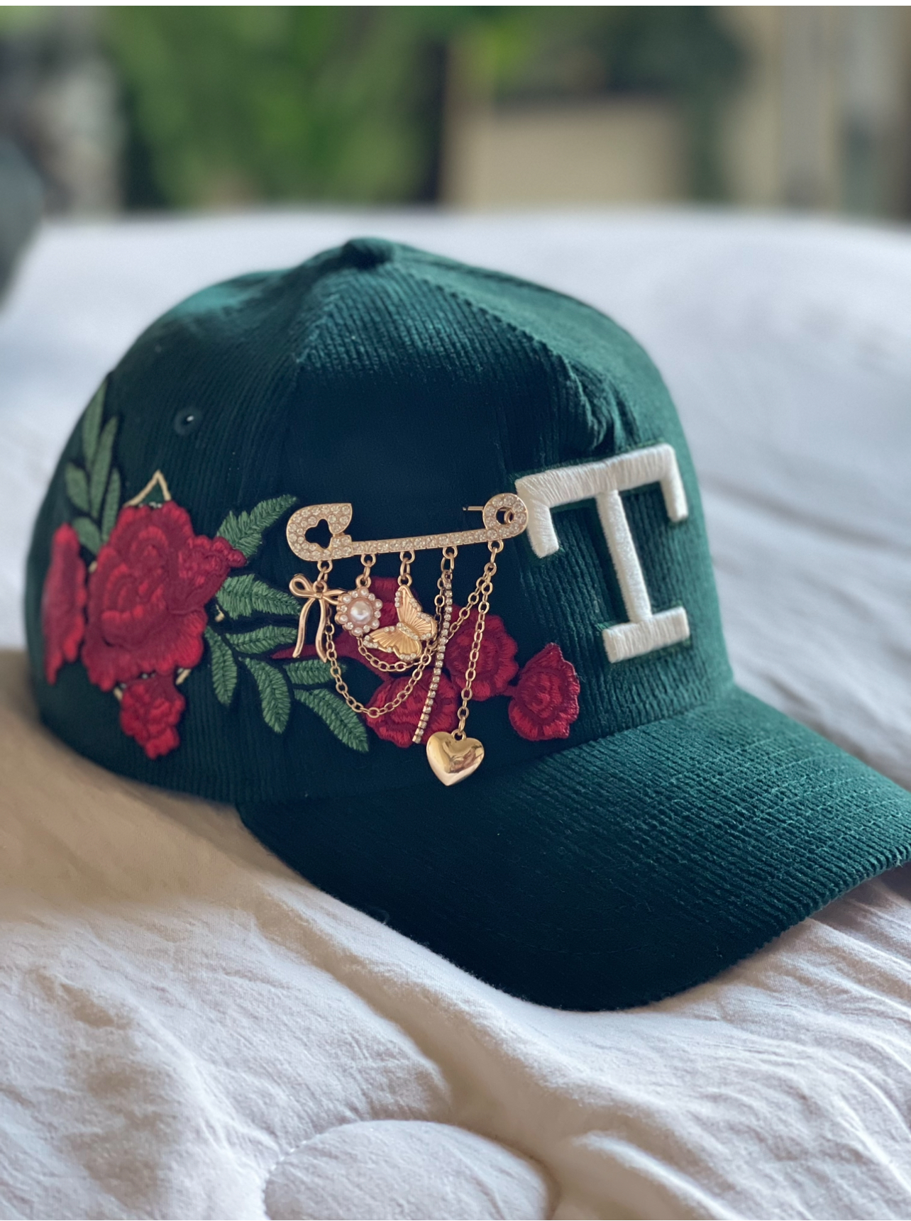 Dark green snapback with personalized T initial, roses and gold charms