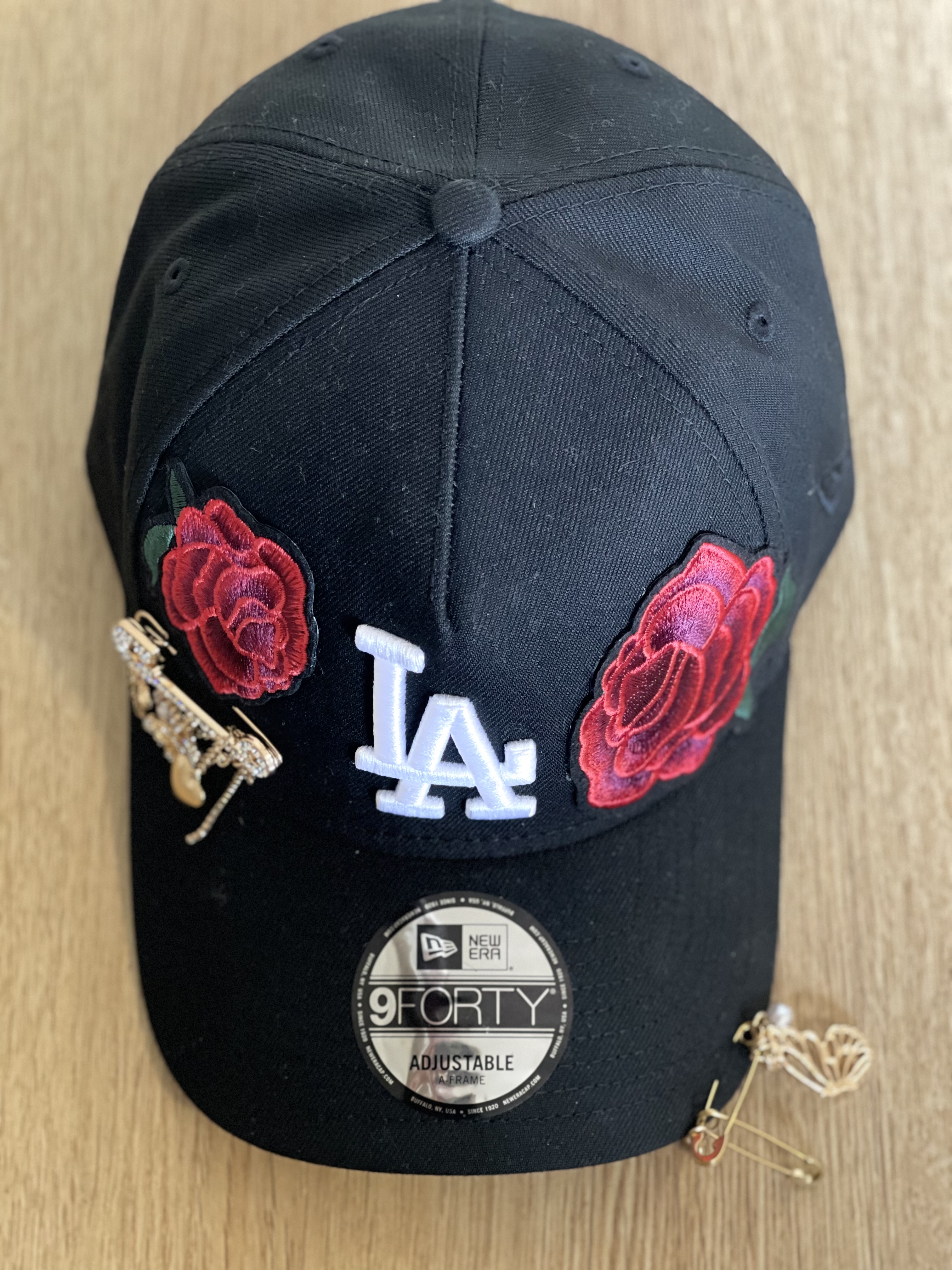 Black LA snapback with rose applique and gold charm brooch detail.