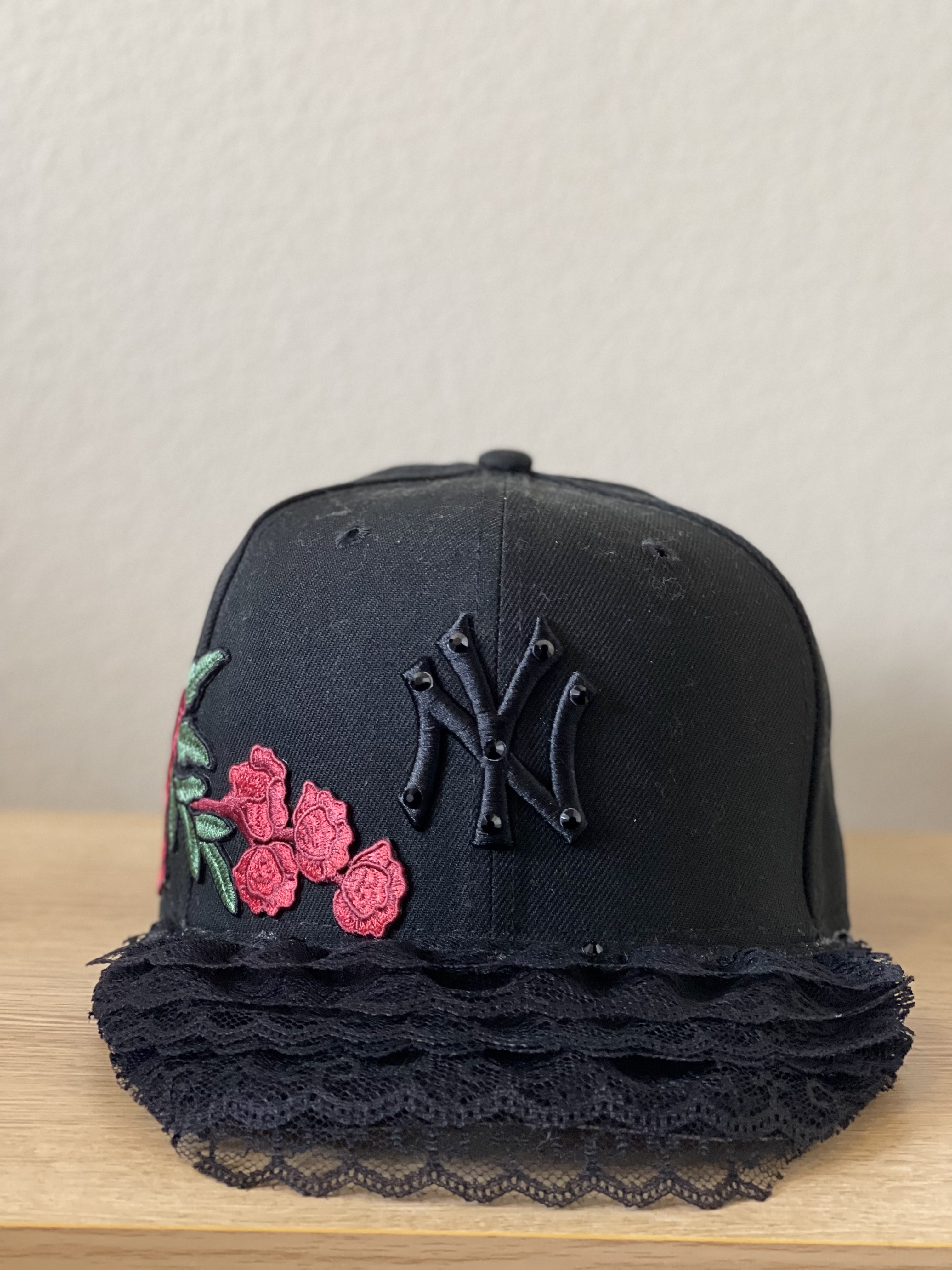 Black Yankees snapback with red floral embroidery and layered lace brim, front view.