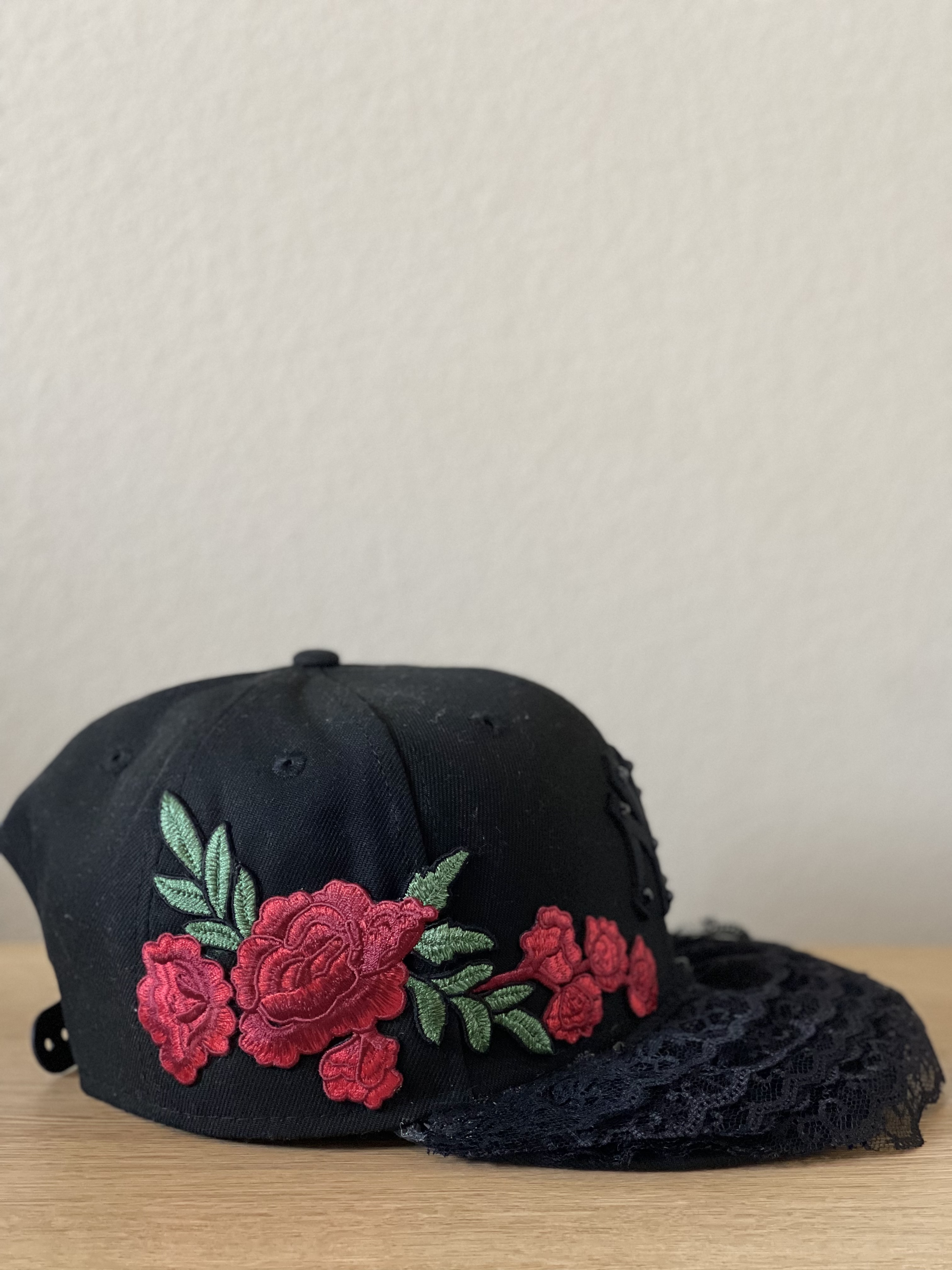 Black Yankees snapback with floral trim wrapping the side panels and lace brim, side profile.