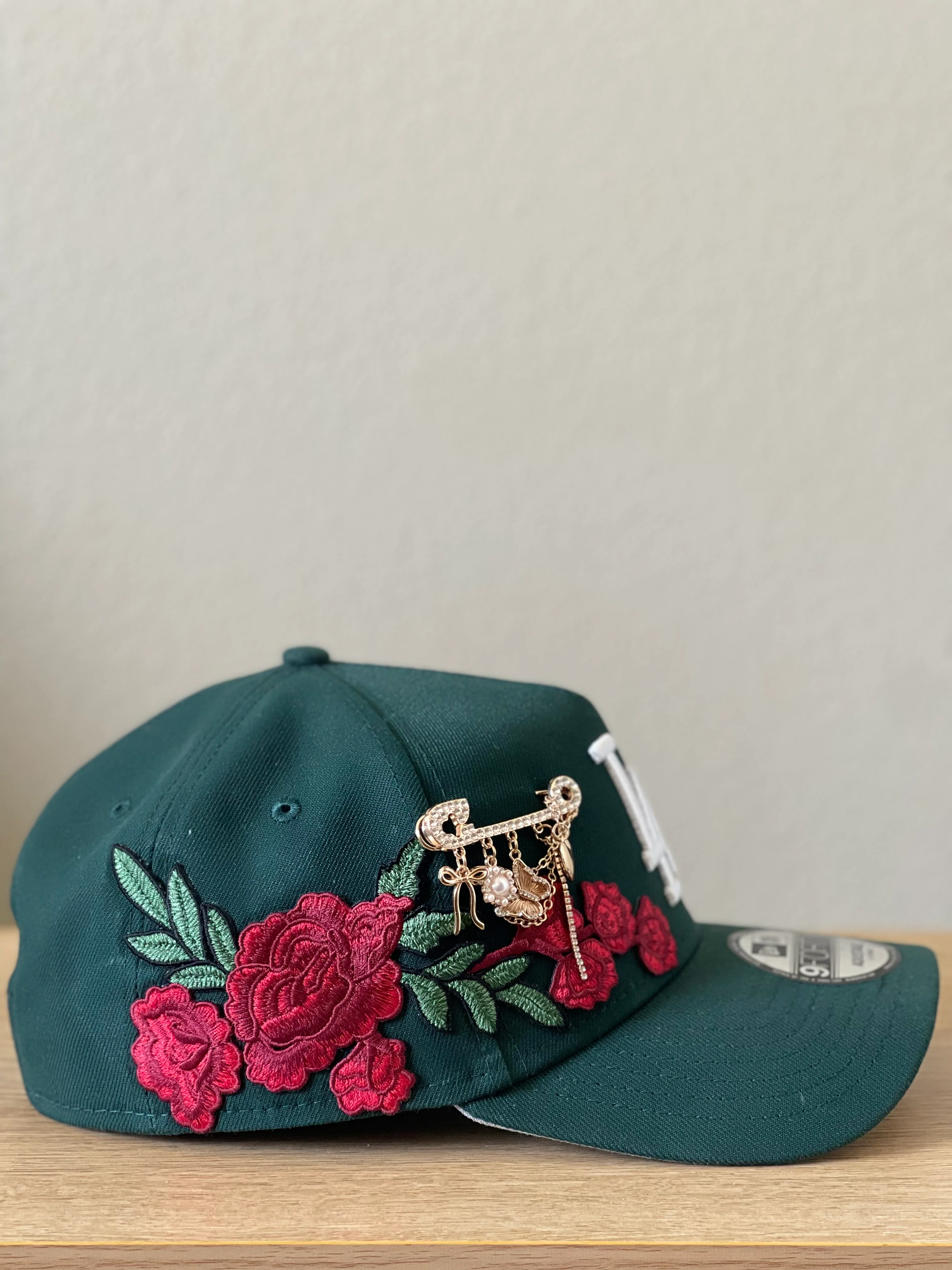 Hunter green snapback with red rose embroidery and gold brooch